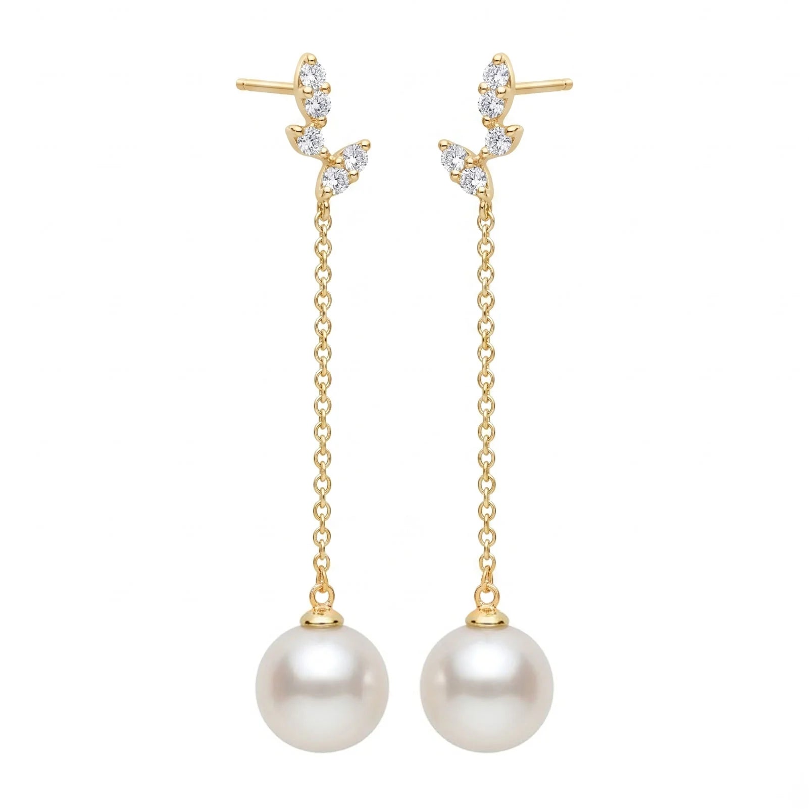 A pair of gold dangle earrings with leaf-shaped settings set with clear stones, hanging chains, and large white pearl drops, shown on a plain white background.