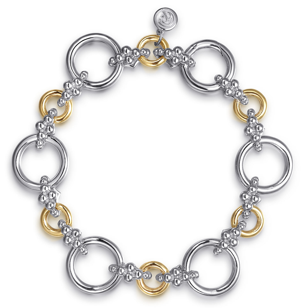 silver and gold tone round link bracelet on white background