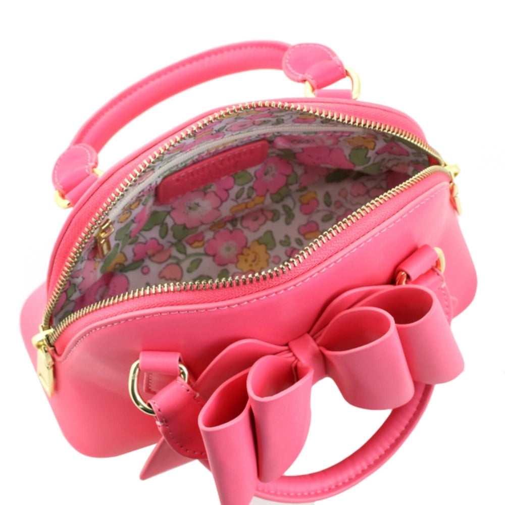 Pink handbag with a large bow and floral interior on a white background
