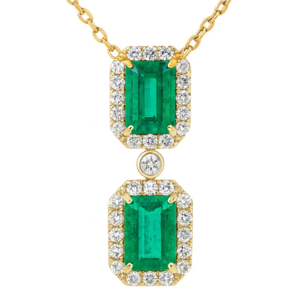 gold tone necklace with 2 green stones and round clear stones on a white background
