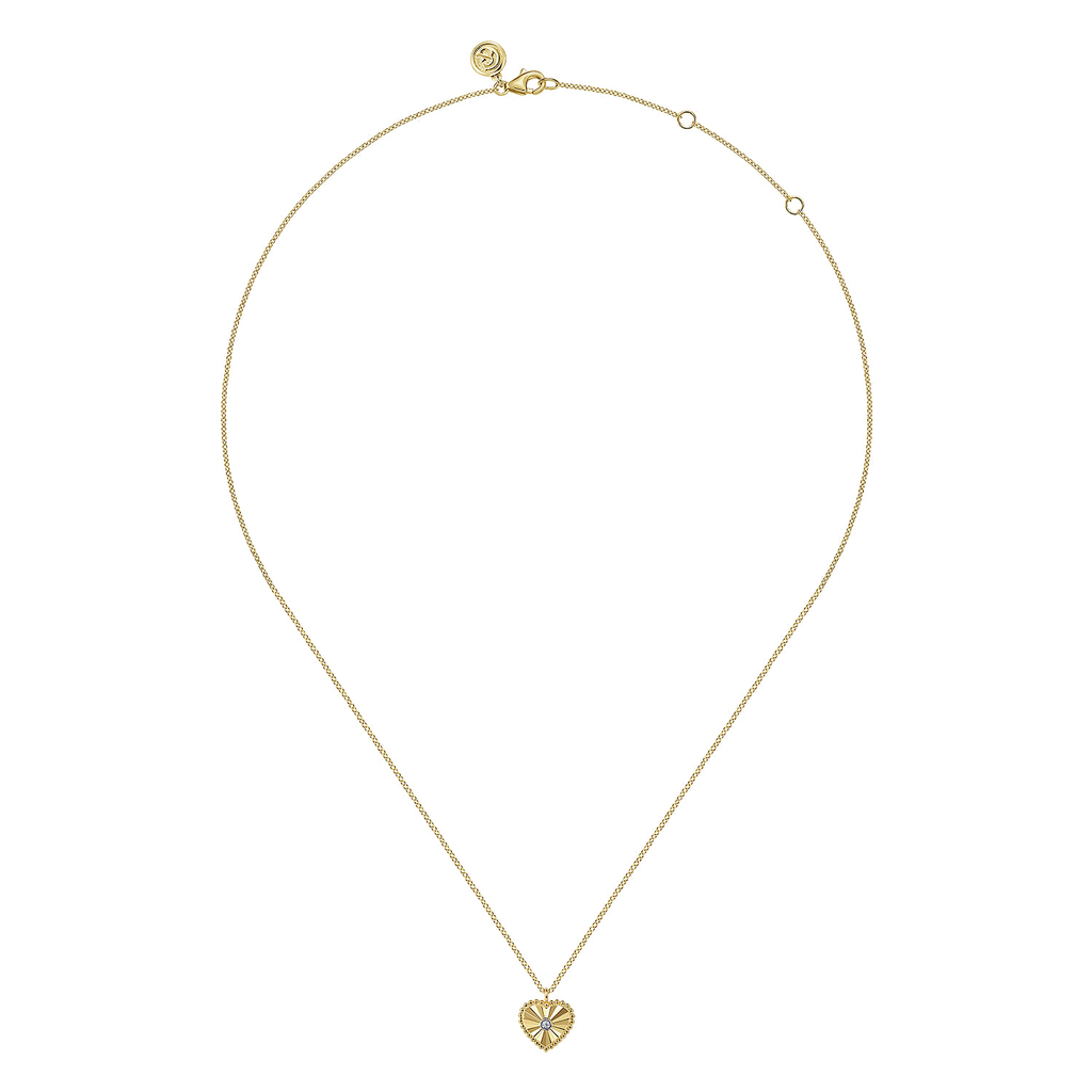 Gold necklace with a heart-shaped pendant on a white background