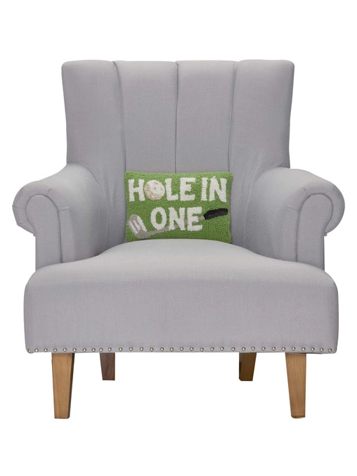 Gray armchair with a green pillow that says 'Hole in One' on a white background