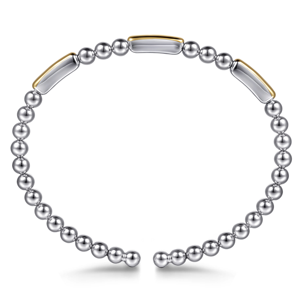 Silver beaded bracelet with gold accents on a white background