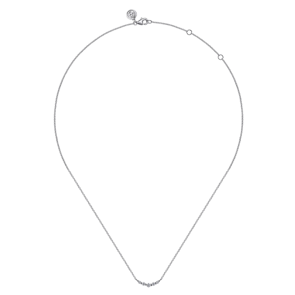 A delicate silver chain necklace with a small curved bar of tiny clear stones at the center, displayed on a solid white background.