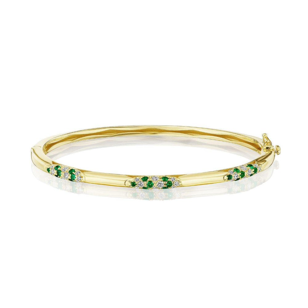 Gold bracelet with green gemstones on a white background