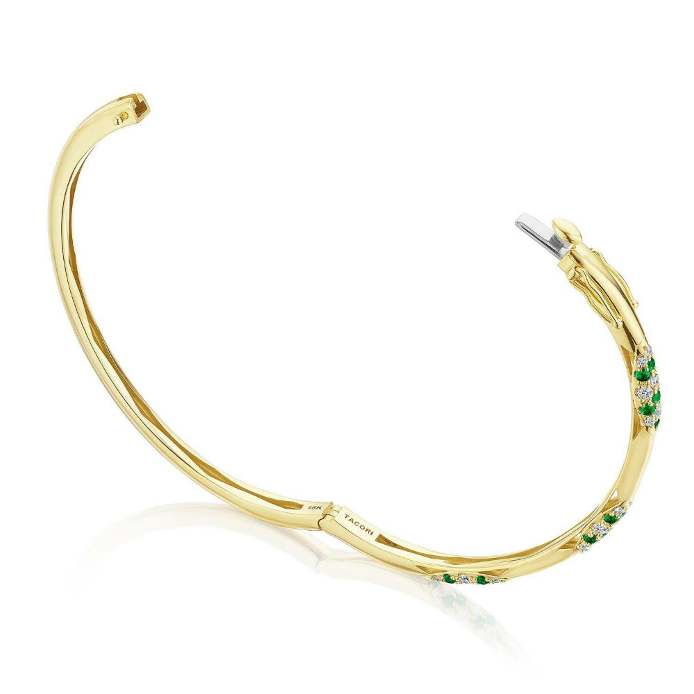 Gold hoop earring with green gemstones on a white background