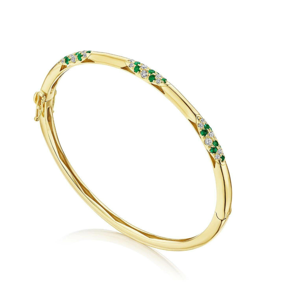 Gold bracelet with green gemstones on a white background