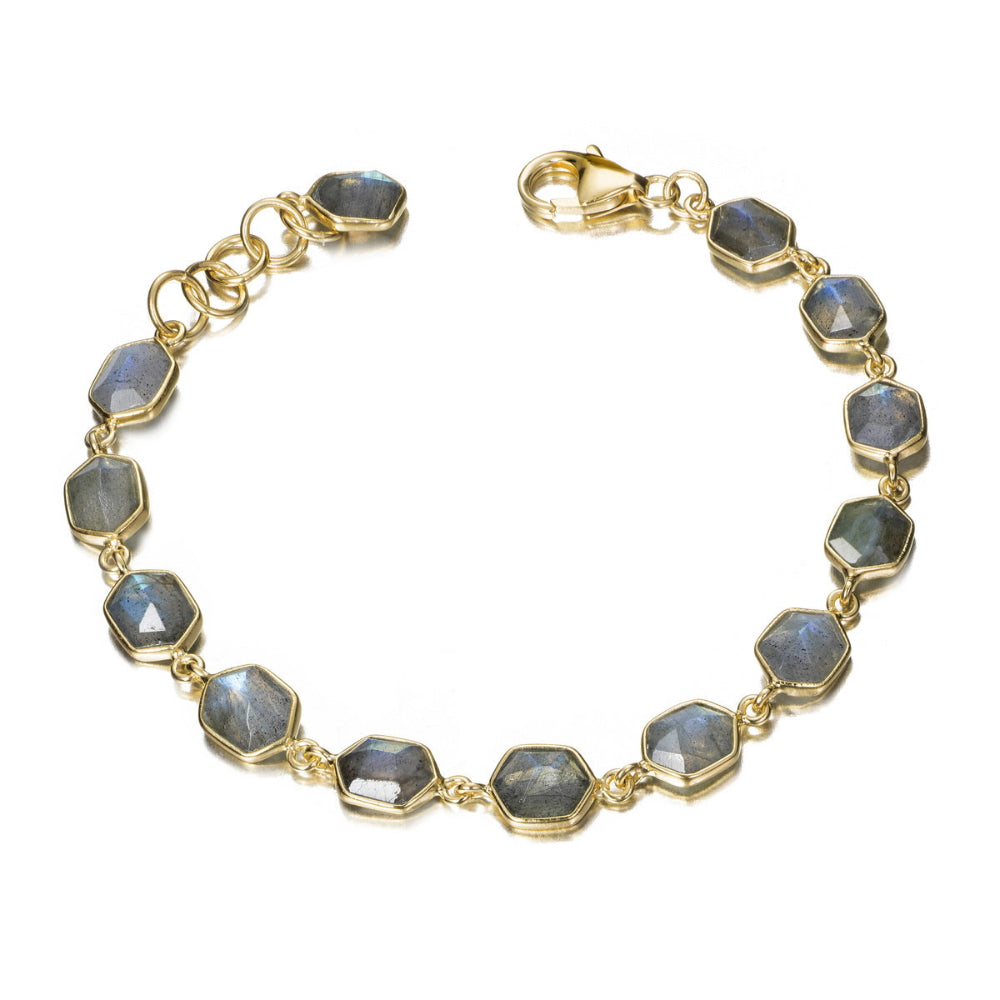 A gold-toned bracelet featuring faceted gray-blue labradorite stones in bezel settings, arranged in a circular shape on a plain white background.