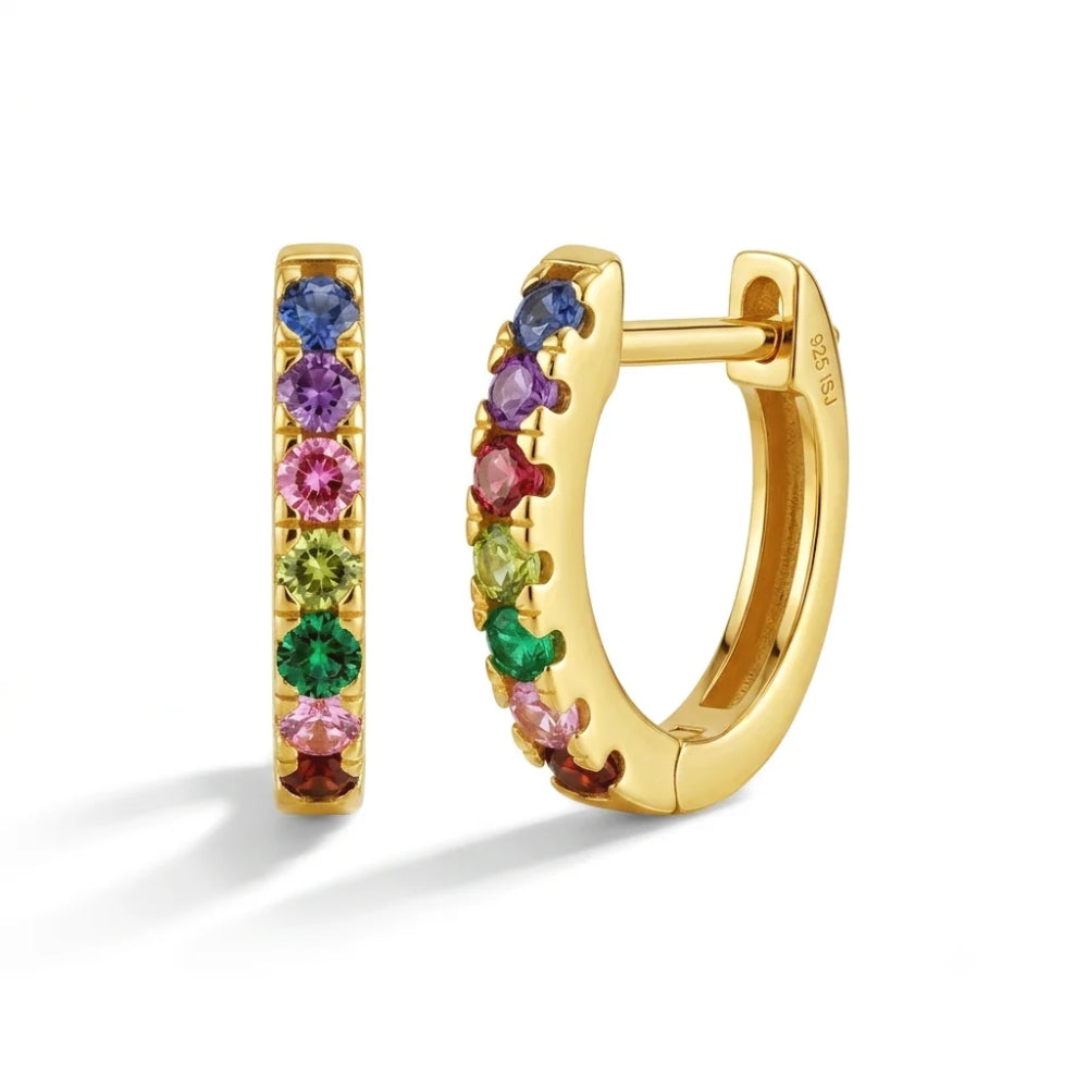 A pair of gold huggie hoop earrings set with a vertical row of colorful round gemstones in pink, purple, blue, green, and red, shown on a clean white background.