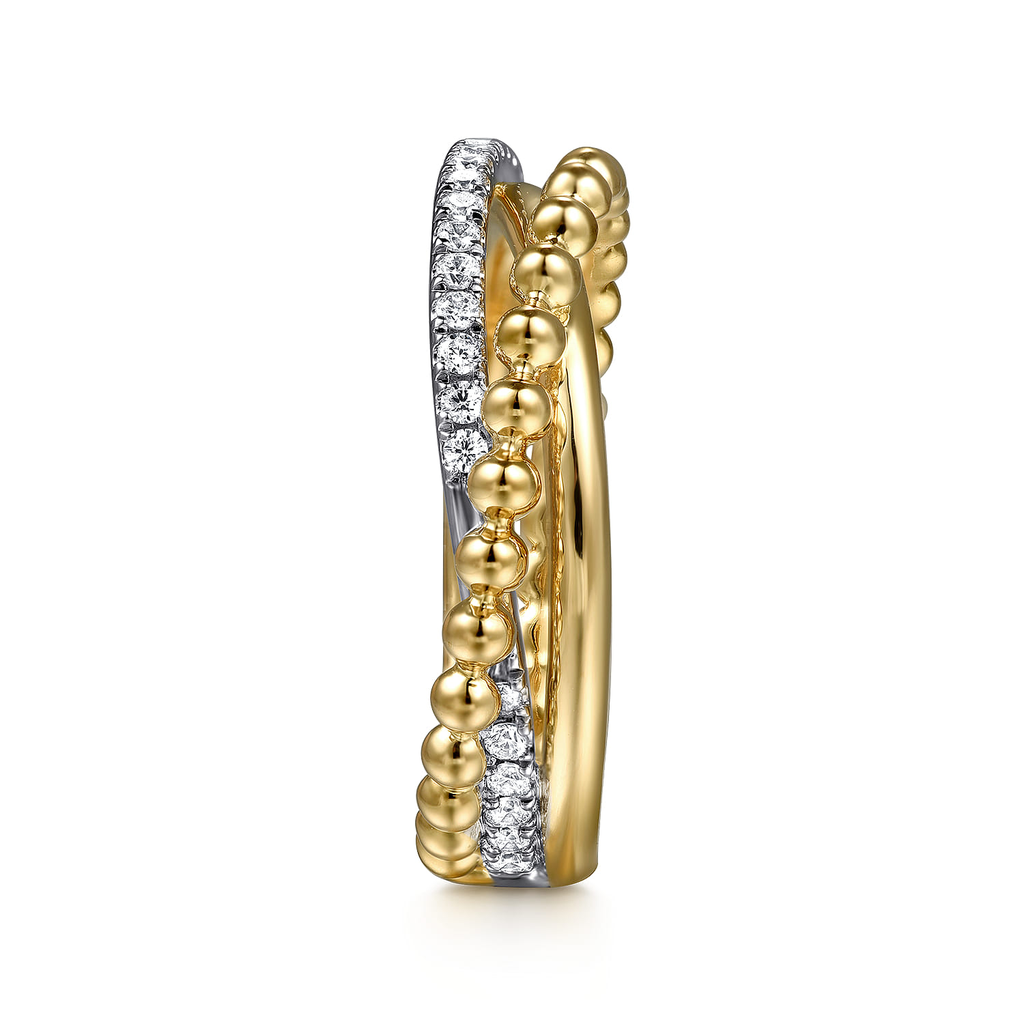 gold and silver ring with clear stones on white background on side