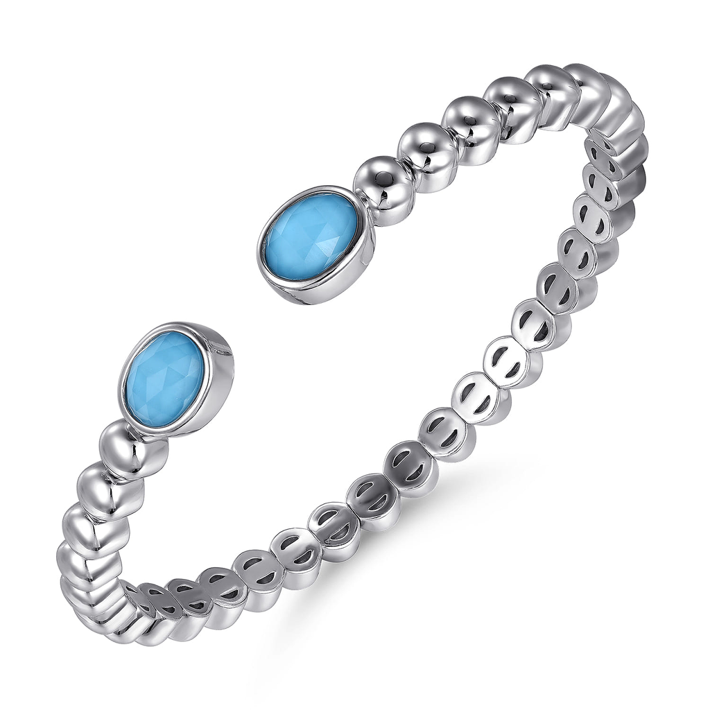 Silver ring with blue gemstones on a white background