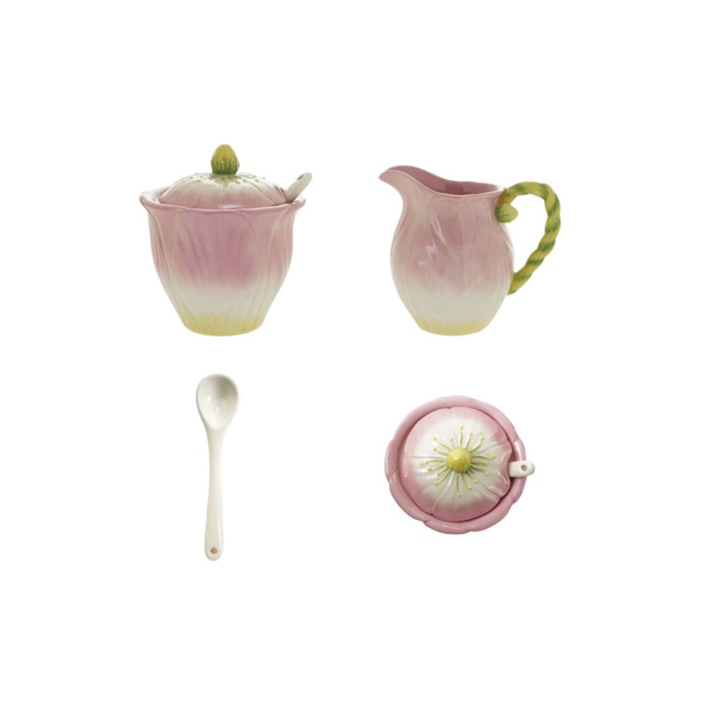 Set of ceramic items including a sugar bowl, creamer, spoon, and tea ball on a white background