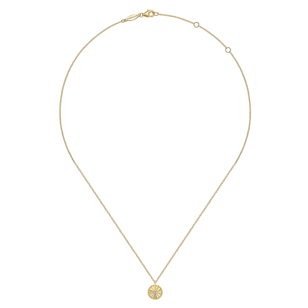 Gold necklace with a small round pendant on a white background