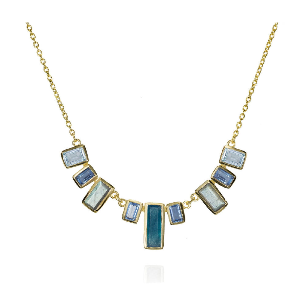 gold-tone necklace with various shades of blue stones on a white backbground