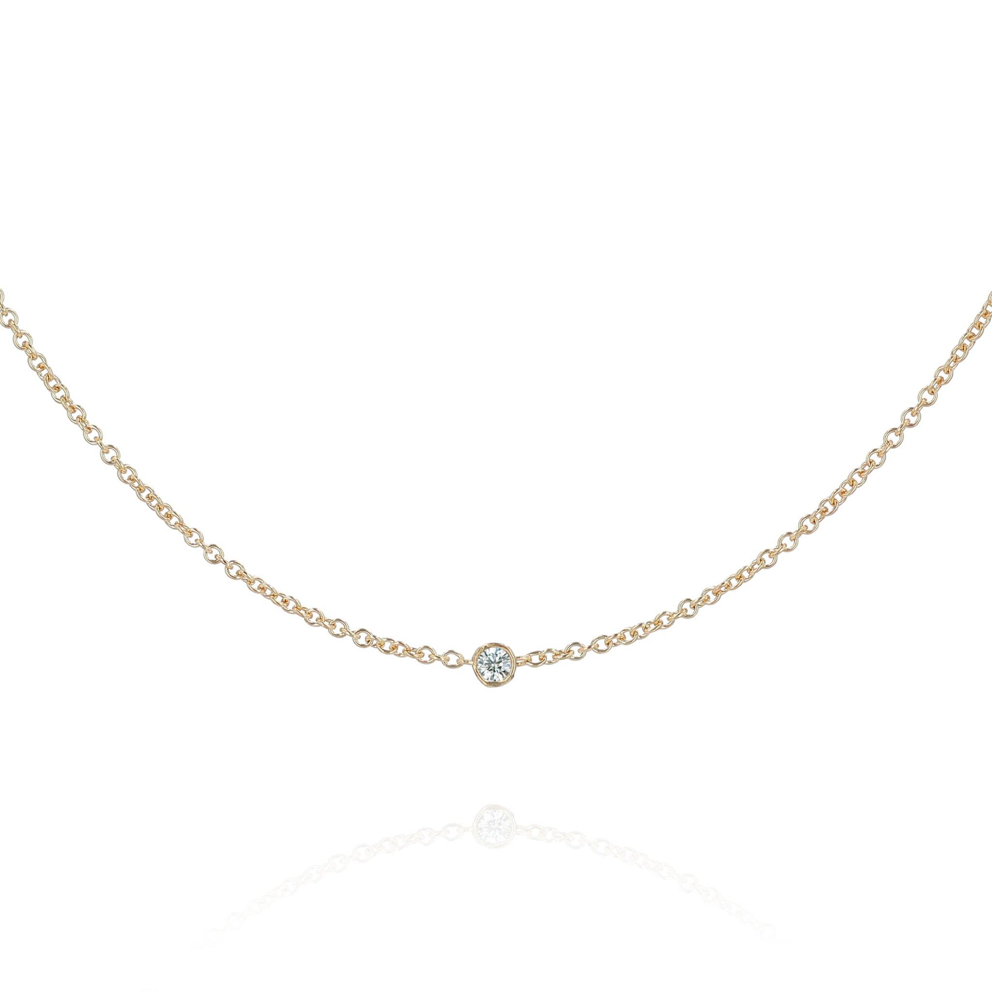 A yellow gold chain with a single diamond station on a white background