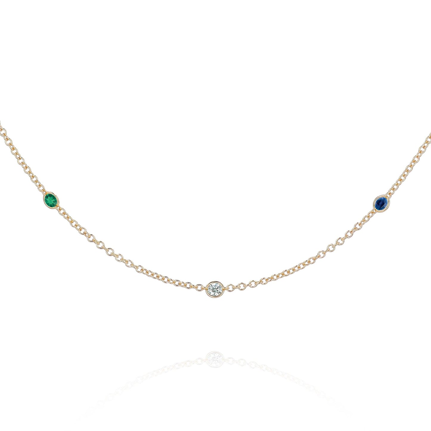 A yellow gold chain with 3 round gemstone stations on a white background