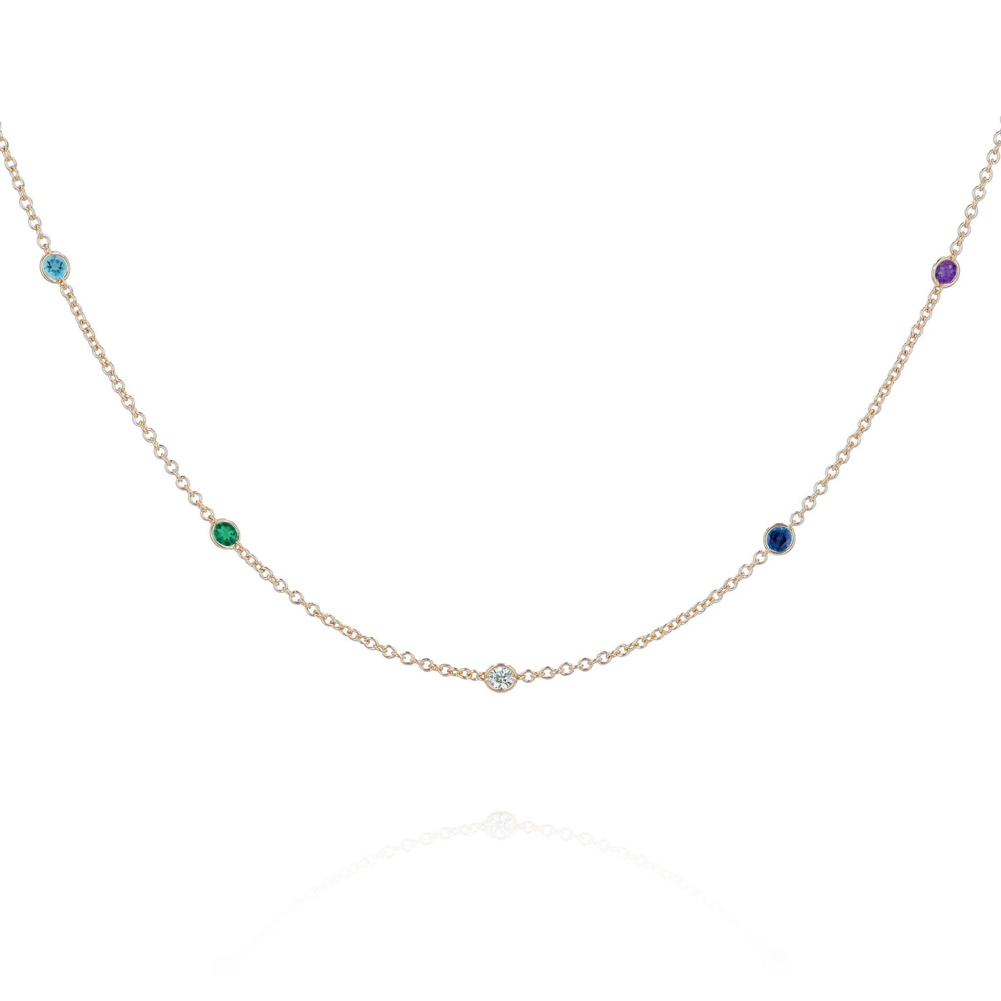 A yellow gold chain with 5 round gemstone stations on a white background