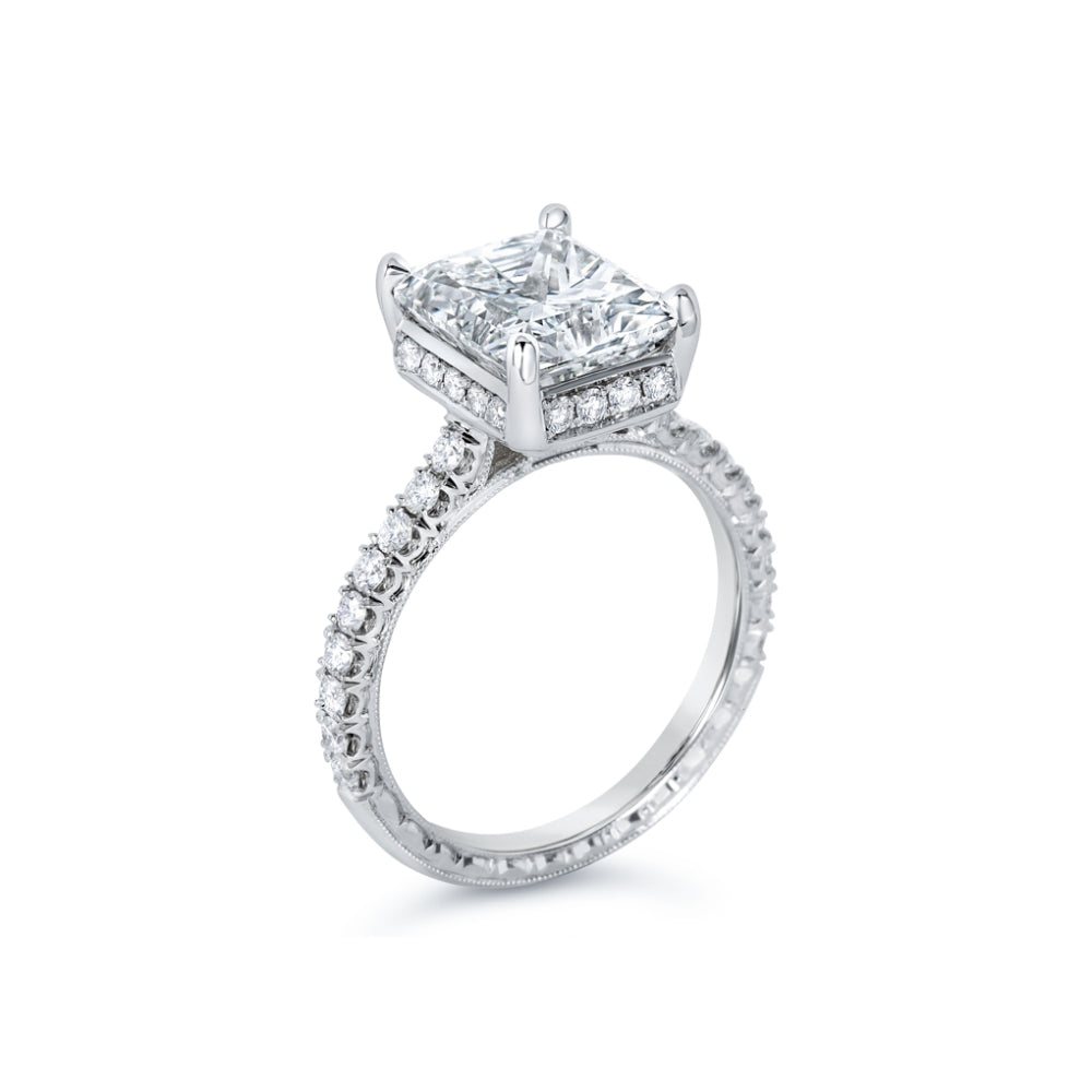 White gold diamond engagement ring with diamond accents and an emerald cut cubic zirconia center on a white background