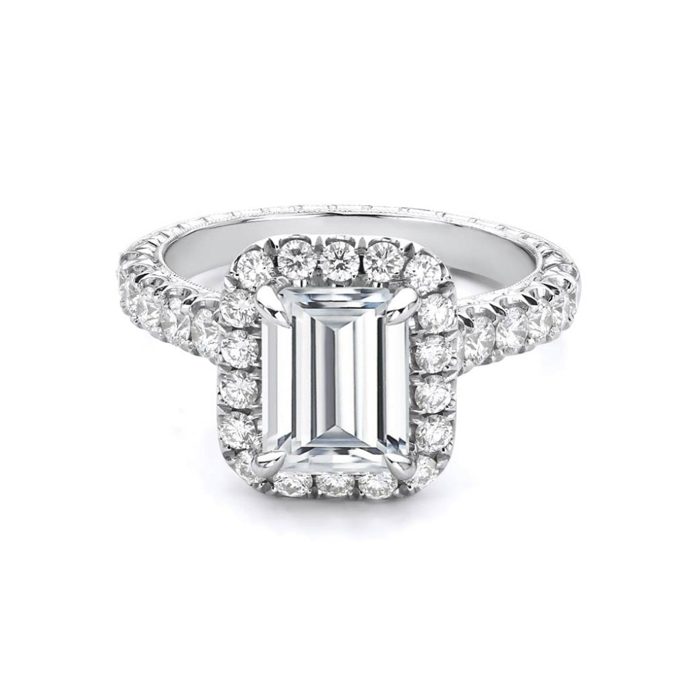 Platinum diamond engagement ring with diamond accents and an emerald cut cubic zirconia center on a white background