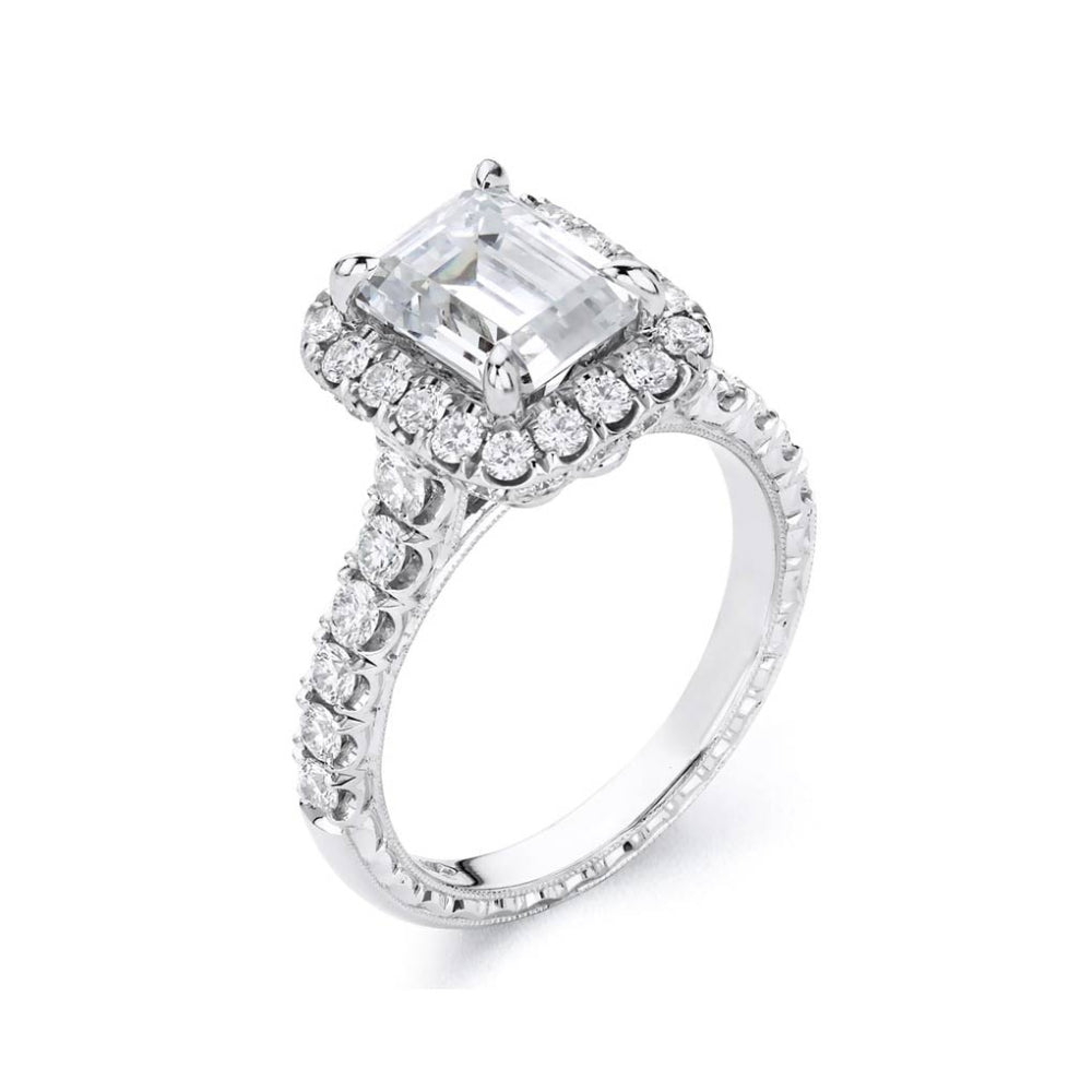 Platinum diamond engagement ring with diamond accents and an emerald cut cubic zirconia center on a white background