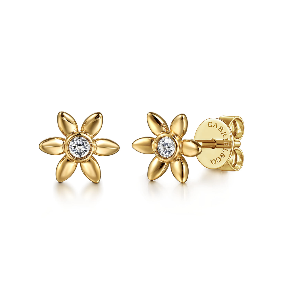 Gold flower-shaped earrings with a central gemstone on a white background