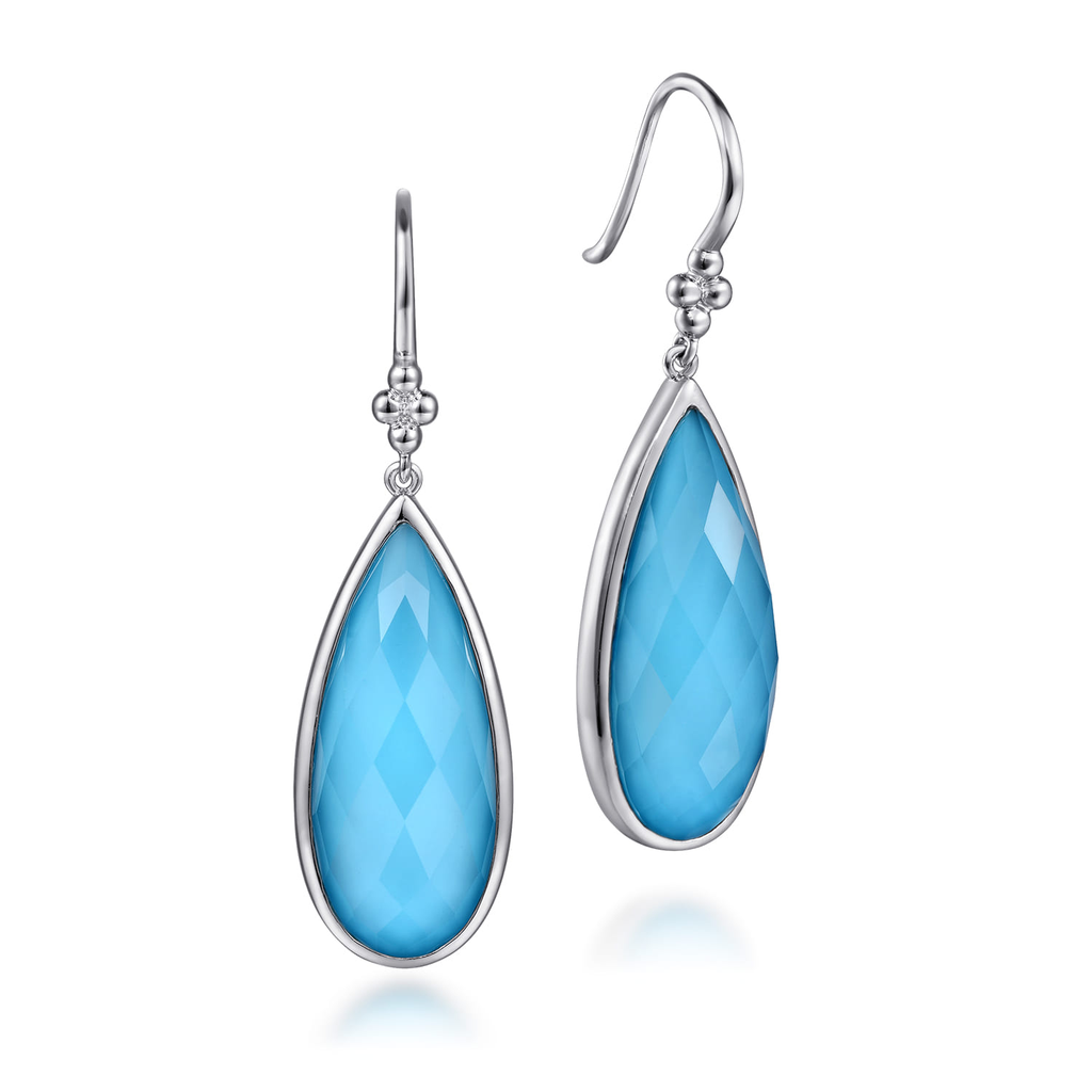 Teardrop-shaped blue earrings with silver hooks on a white background
