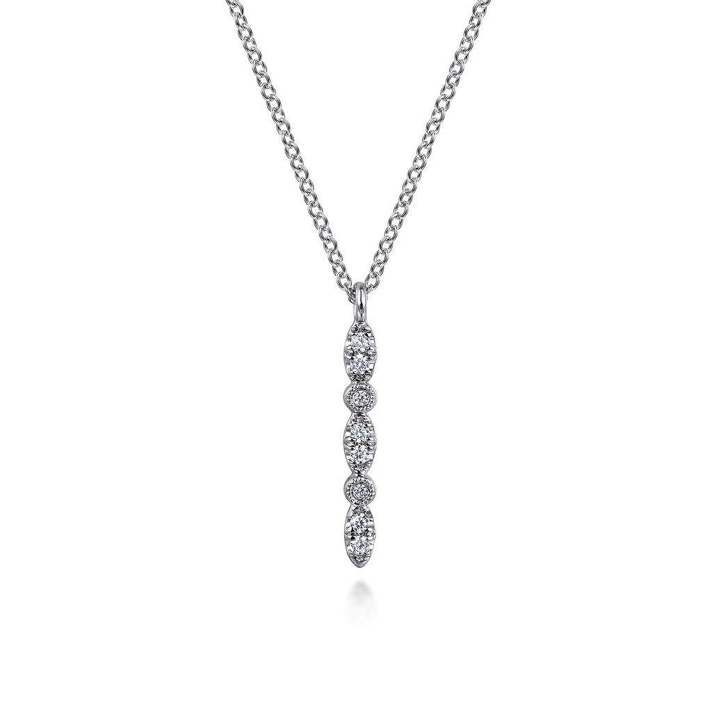 A silver-toned necklace with a vertical drop pendant featuring five marquise-cut and round stones, displayed on a clean white background.