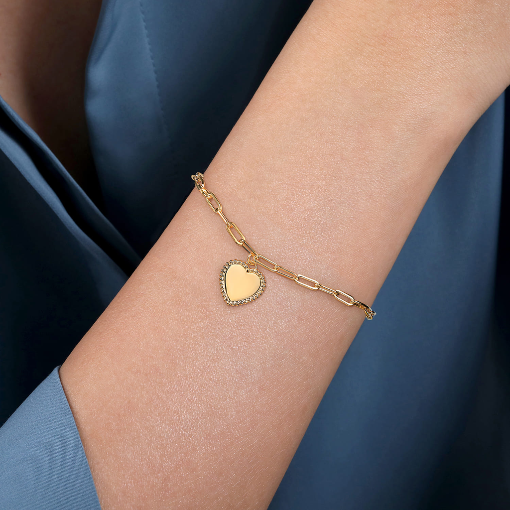 model wearing gold bracelet with heart drop 
