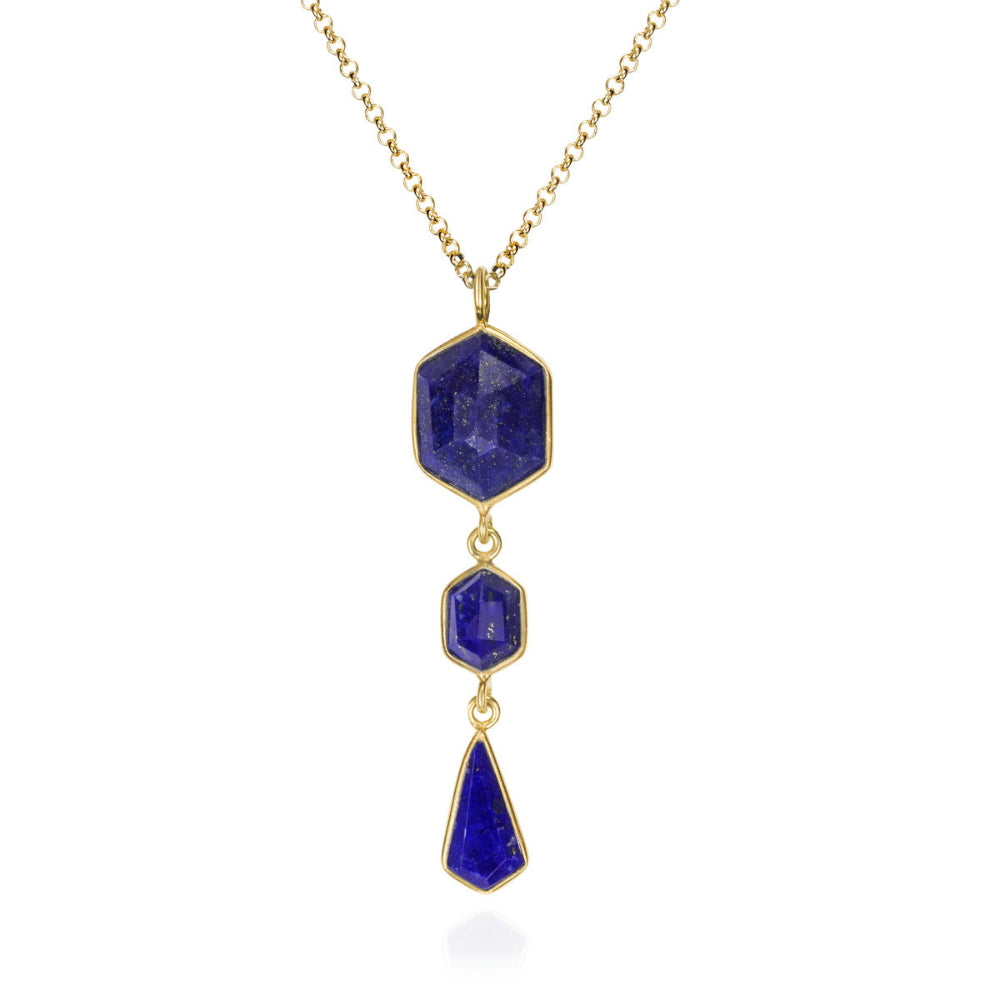 A gold chain necklace featuring a vertical dangle pendant with three stacked geometric blue gemstone drops in hexagon, hexagon, and teardrop shapes, set against a plain white background.
