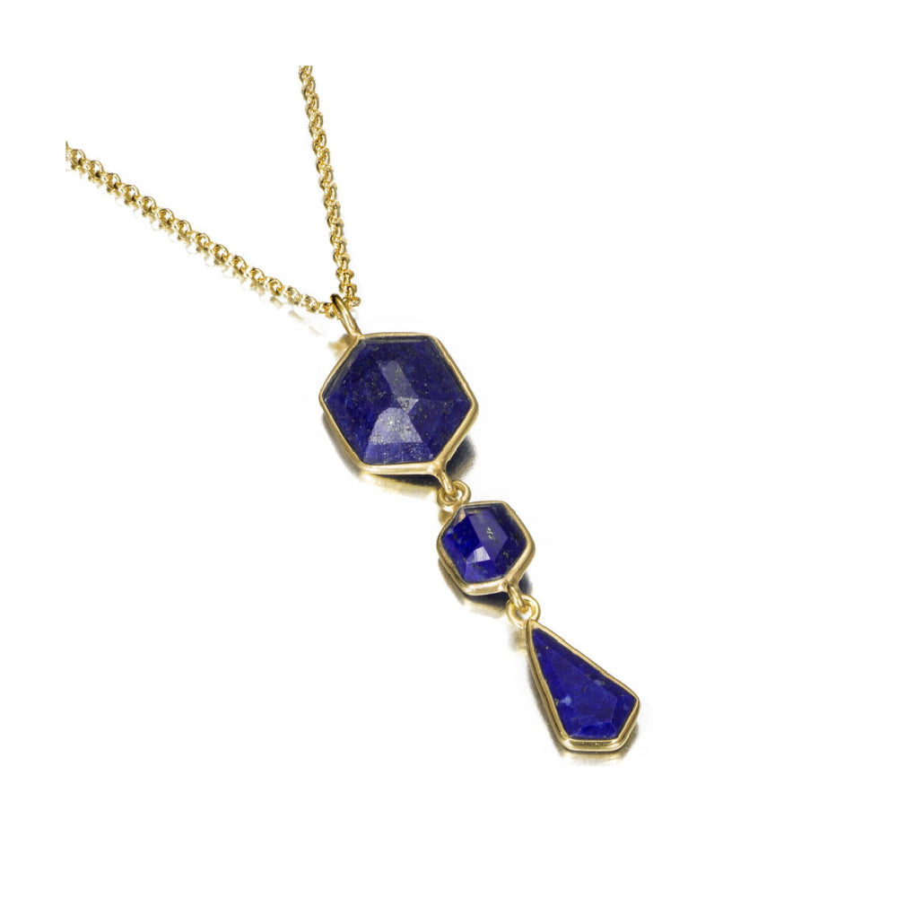 A gold chain necklace featuring three dangling lapis lazuli stones of different shapes and sizes, set in gold bezels, shown on a plain white background.