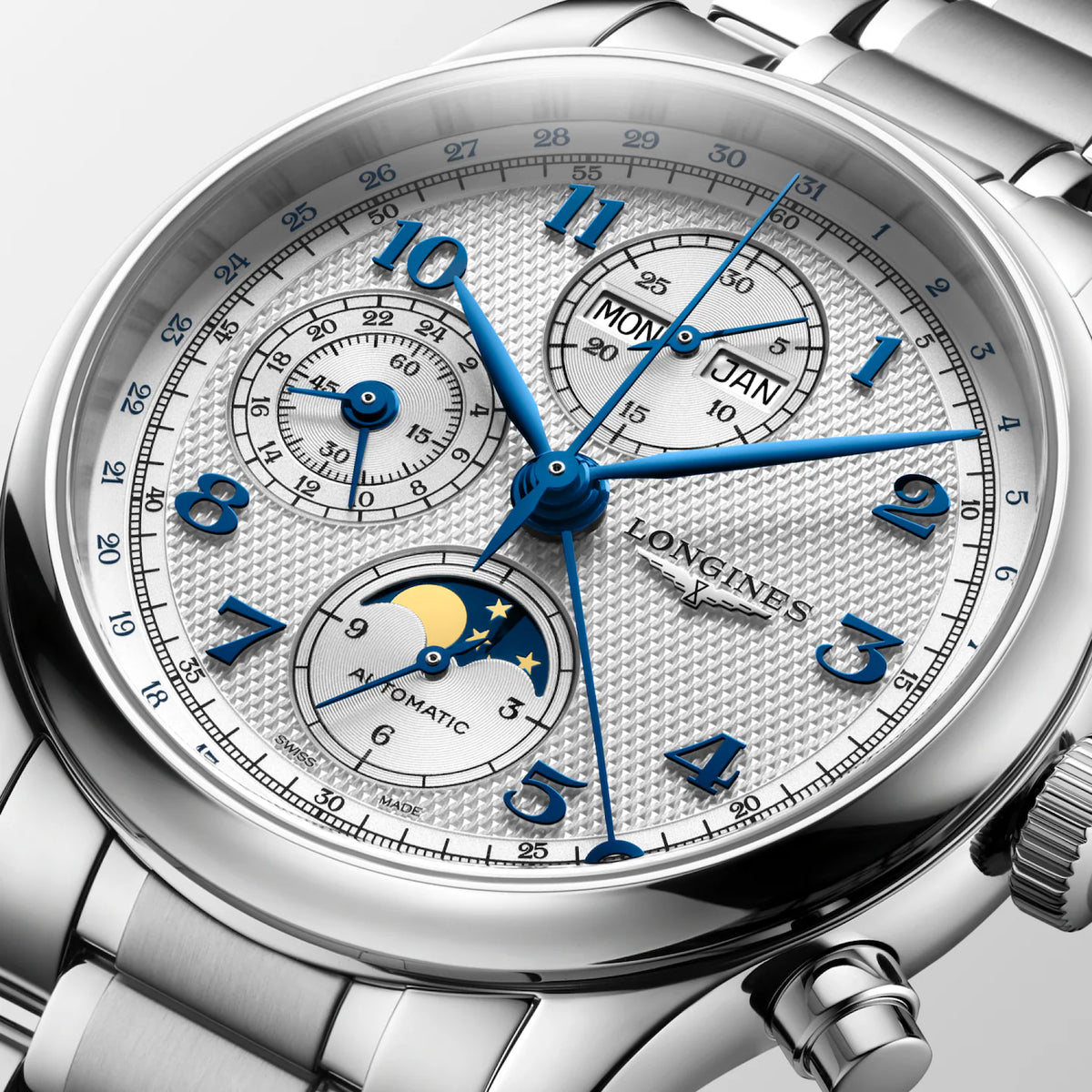 Close-up of a Longines Silver Automatic chronograph watch with a silver textured dial, blue hands and markers, and a stainless steel link bracelet.