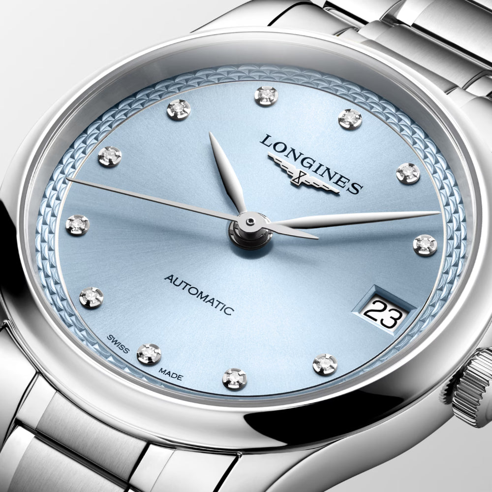 Close-up of a Longines Automatic watch with a light blue dial, silver stainless steel case and bracelet, crystal hour markers, and a date window showing 23.