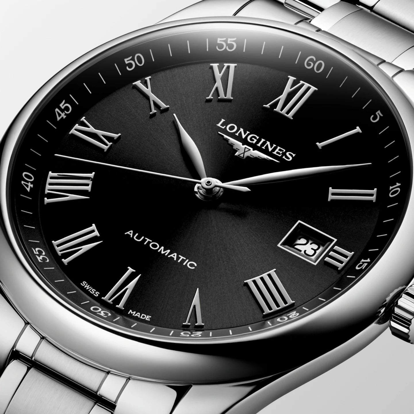 Longines watch with black dial and silver case on a light gray background