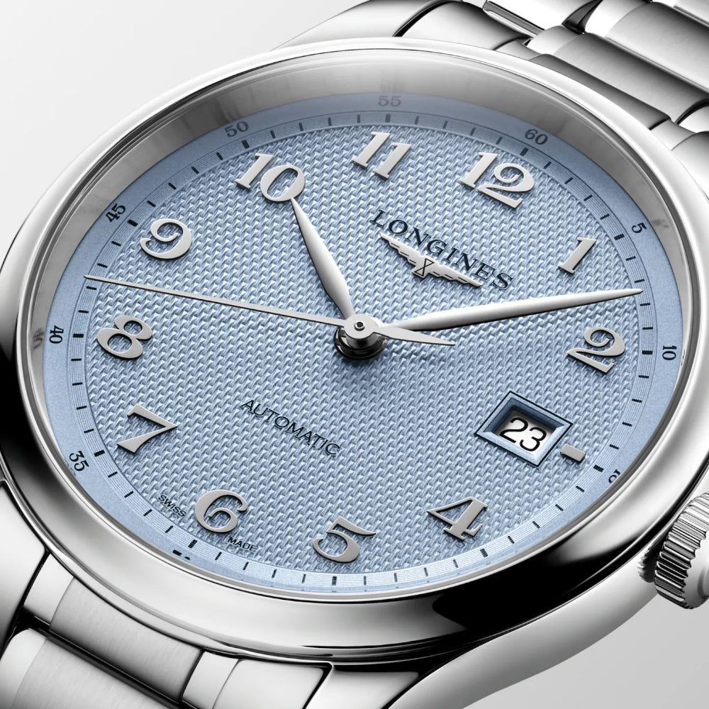 Close-up of a Longines Automatic watch with a silver stainless steel bracelet and a textured light blue dial.