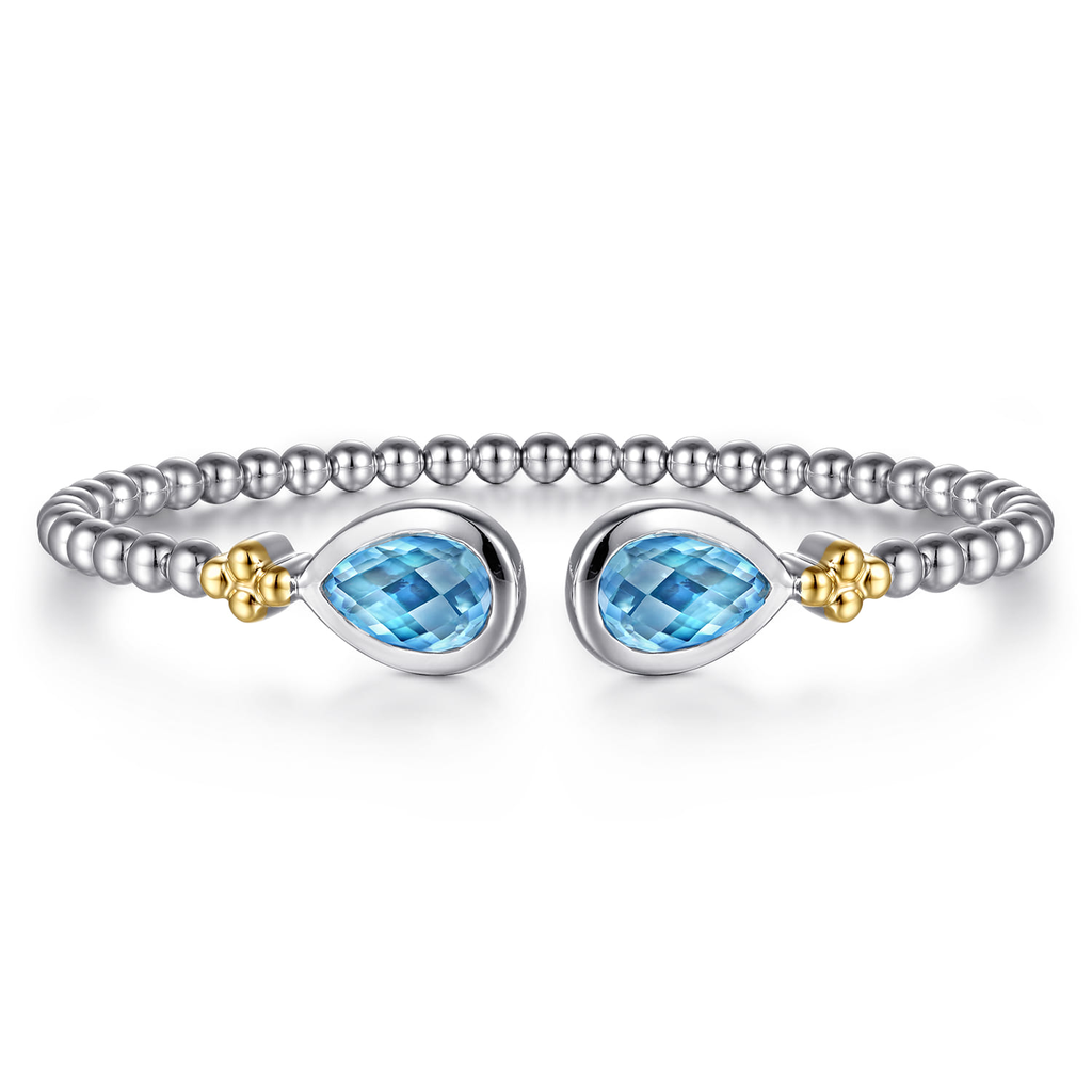 Silver bracelet with blue gemstones and gold accents on a white background