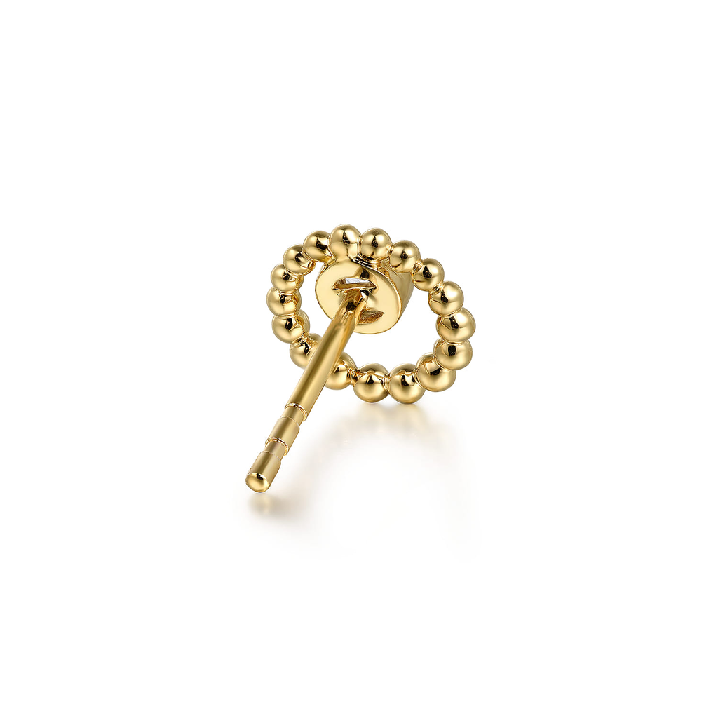 Gold key-shaped earring on a white background