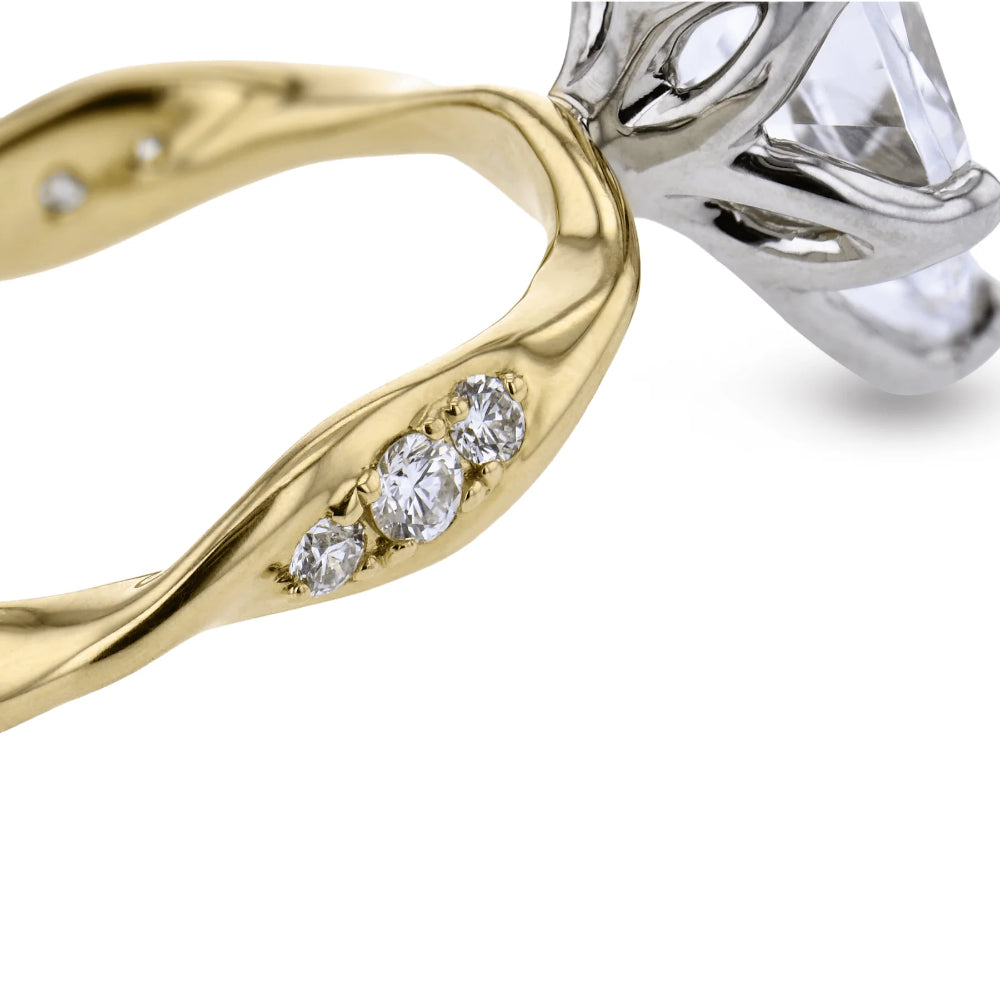 A close-up of a split-metal ring featuring a polished yellow gold band with three small clear stones and a silver-toned setting holding a large clear gemstone, shown on a white background.