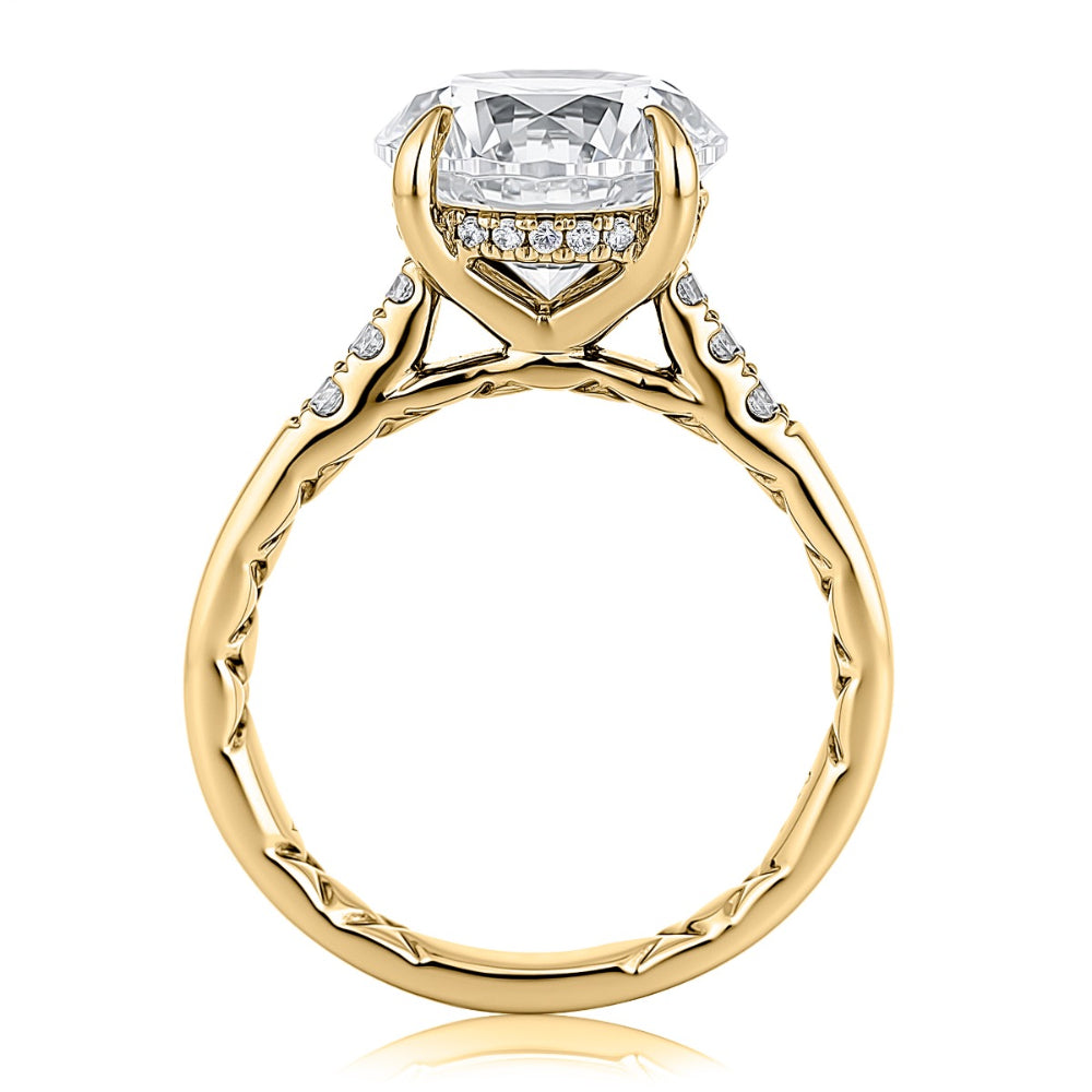 A yellow gold diamond ring with a large round-cut center stone and small accent diamonds along the shoulders, shown on a clean white background.