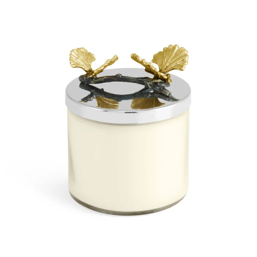 Decorative candle with gold shell design on a white background
