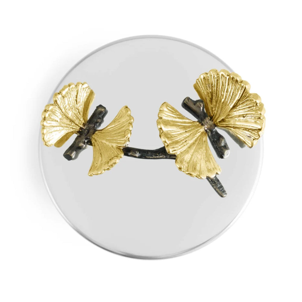 Top view of a Candle with butterfly like gold designs on a white background. 