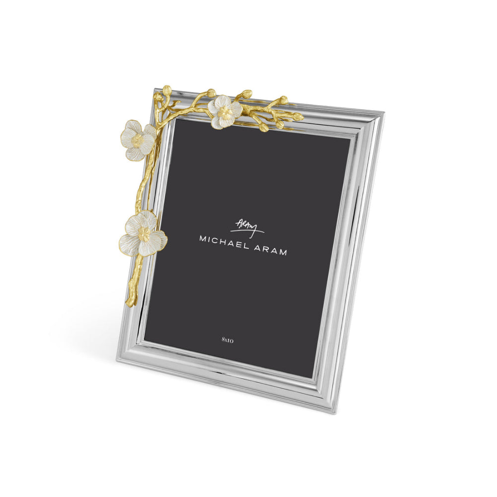 An elegant photo frame with a gold and white enamel design, featuring an orchid motif, from the Michael Aram brand.