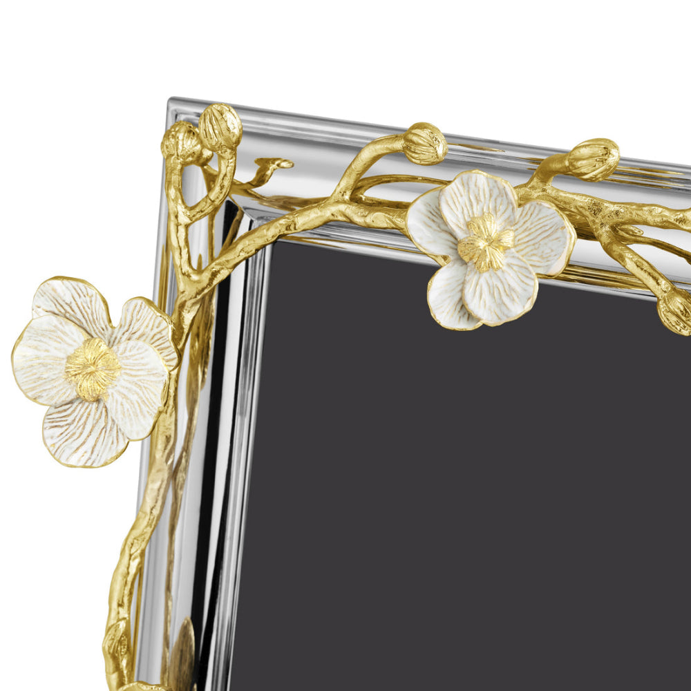 An elegant photo frame with a gold and white enamel design, featuring an orchid motif, from the Michael Aram brand.