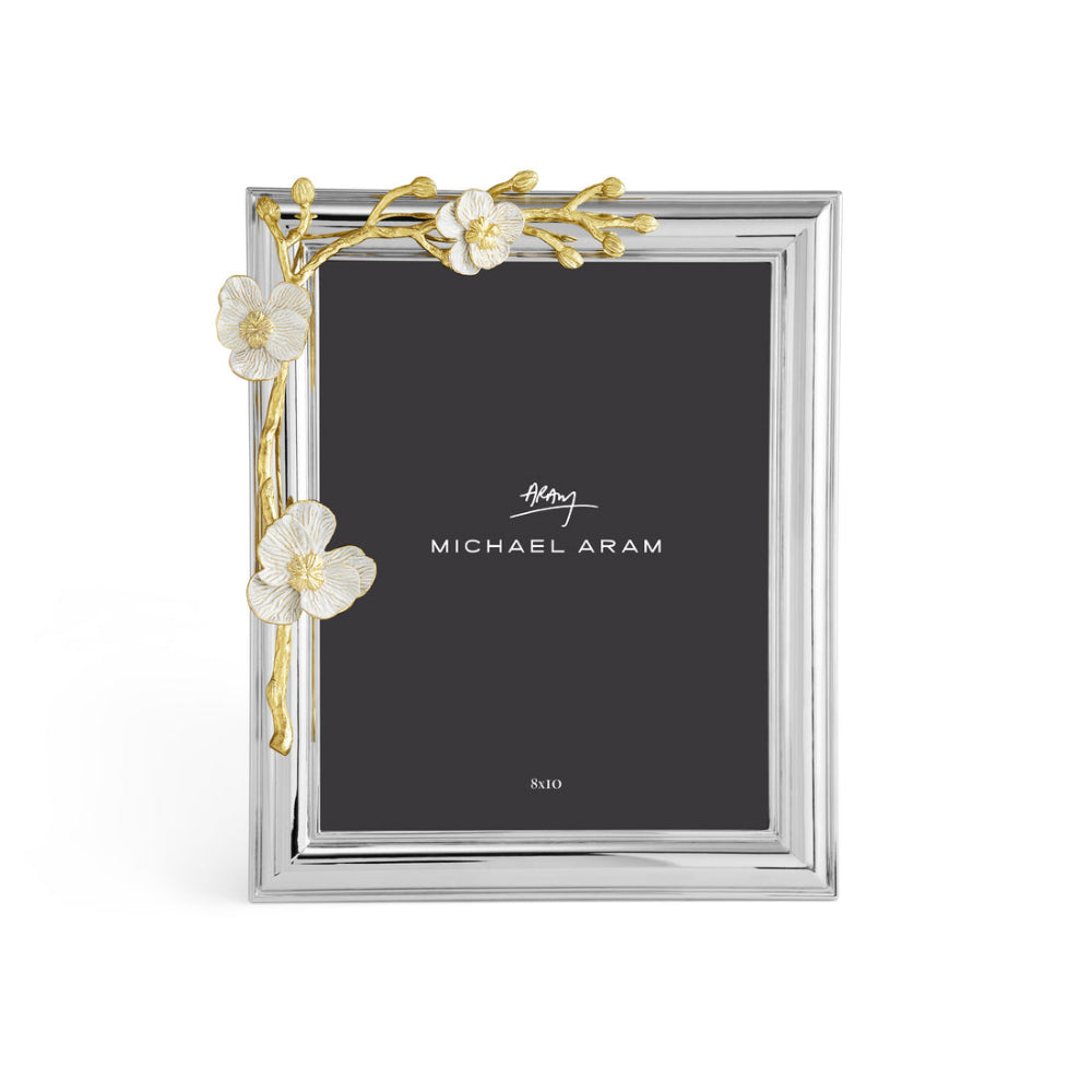 An elegant photo frame with a gold and white enamel design, featuring an orchid motif, from the Michael Aram brand.