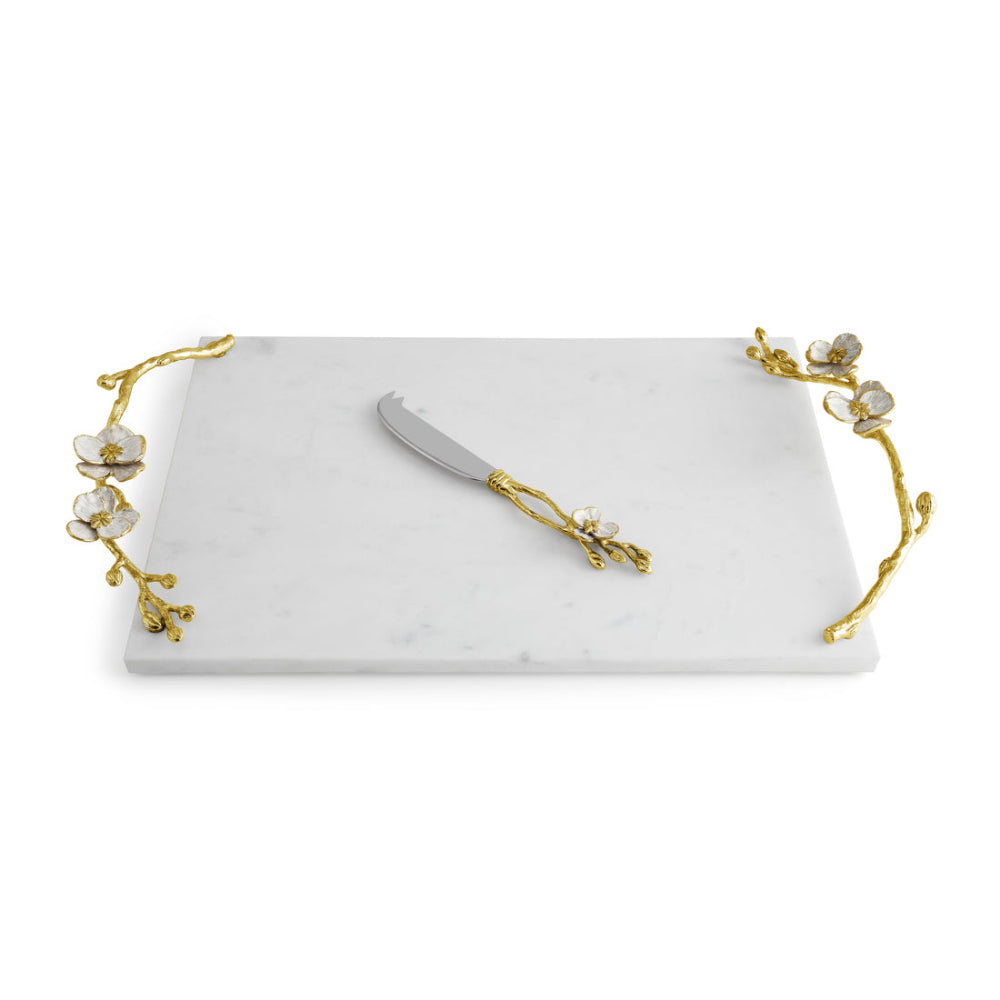 A white marble cheese board with gold Orchid detailing and a matching knife.