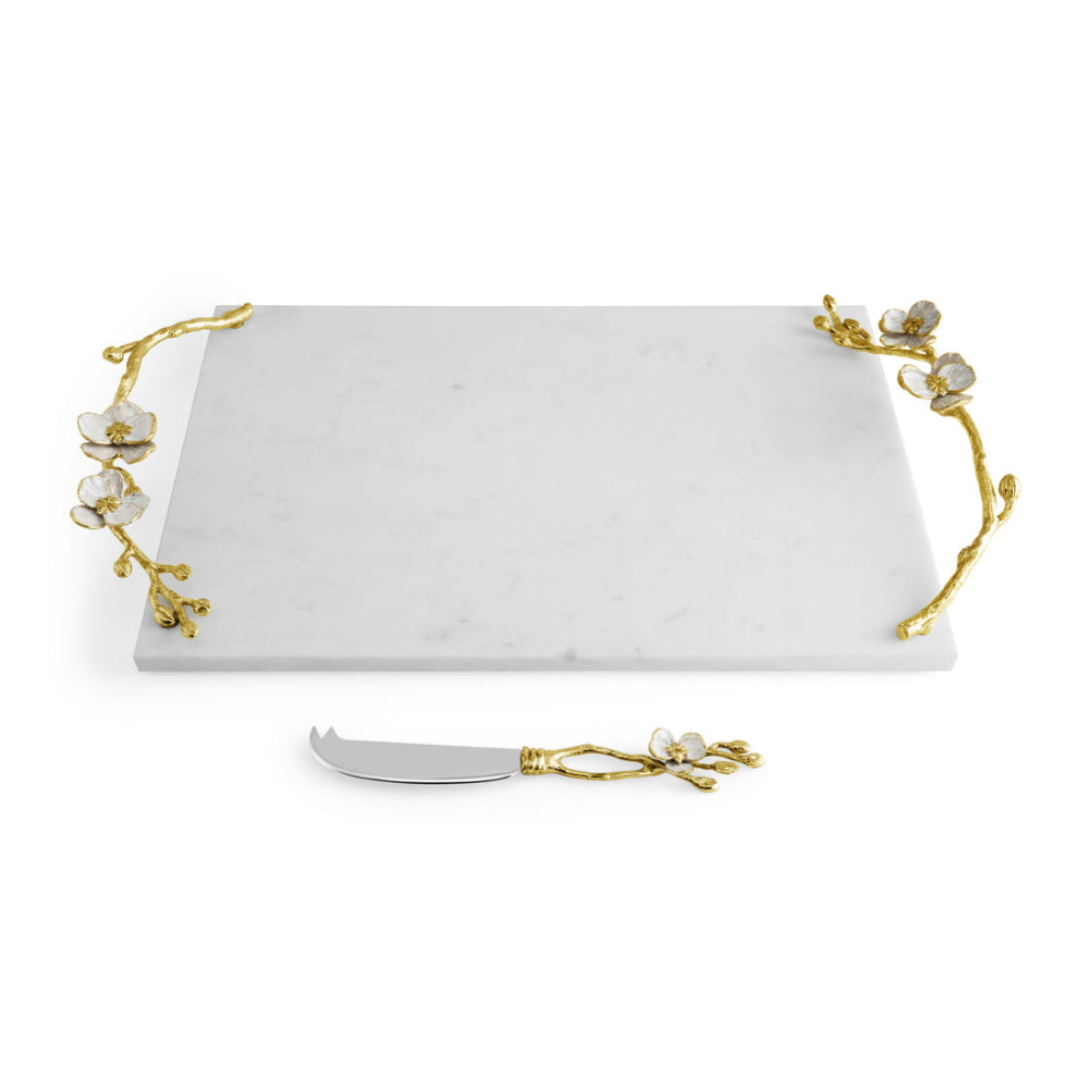 A white marble cheese board with gold Orchid detailing and a matching knife.