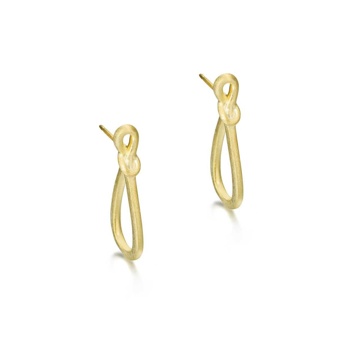 A pair of gold huggie hoop earrings with a small central knot detail, shown on a clean white background.