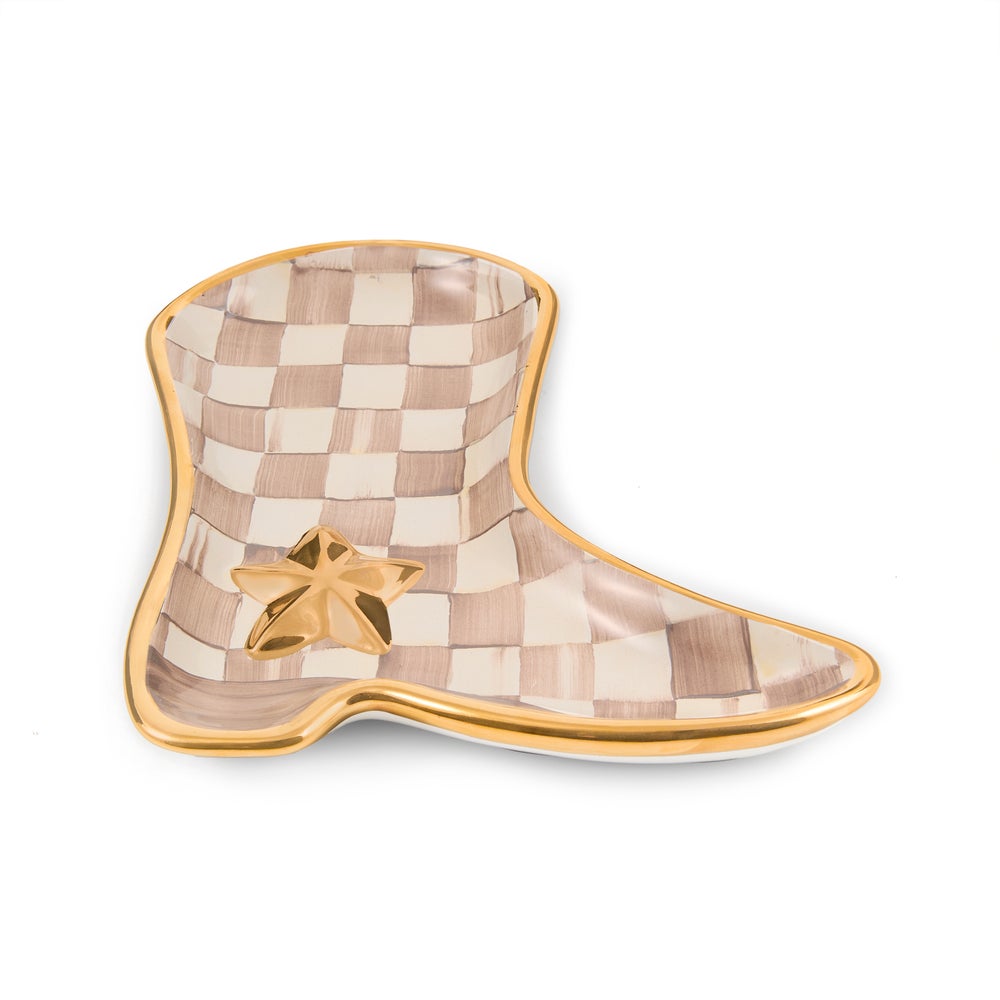 A decorative boot-shaped ceramic dish featuring a beige and cream checkerboard pattern, a polished gold rim, and a small gold star accent on the lower front, shown on a clean white background.