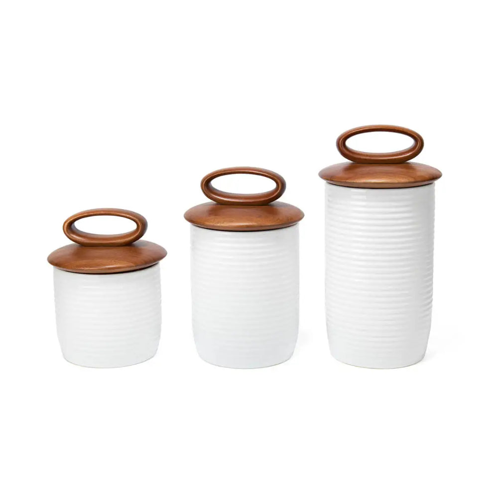 three white canisters with brown lids on a white background
