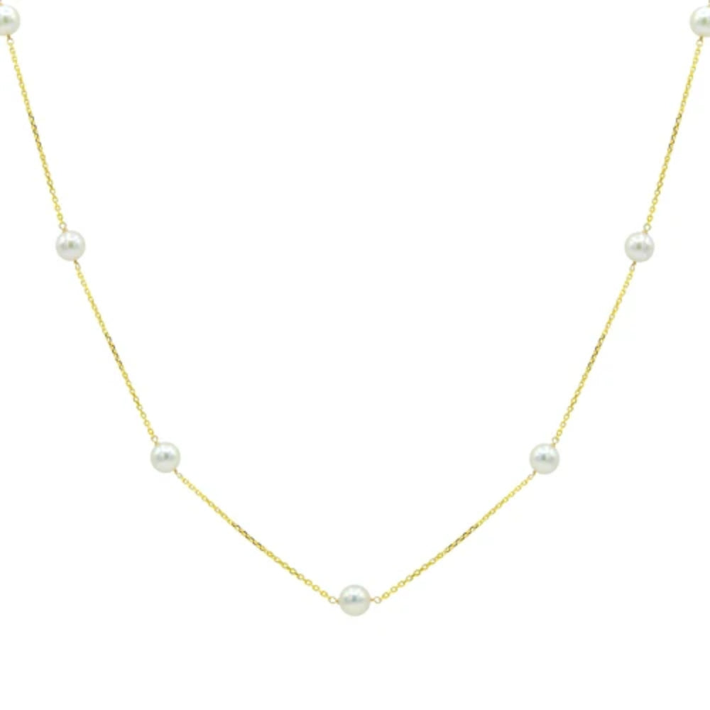 A delicate gold chain necklace featuring seven evenly spaced white freshwater pearls, displayed against a solid white background.