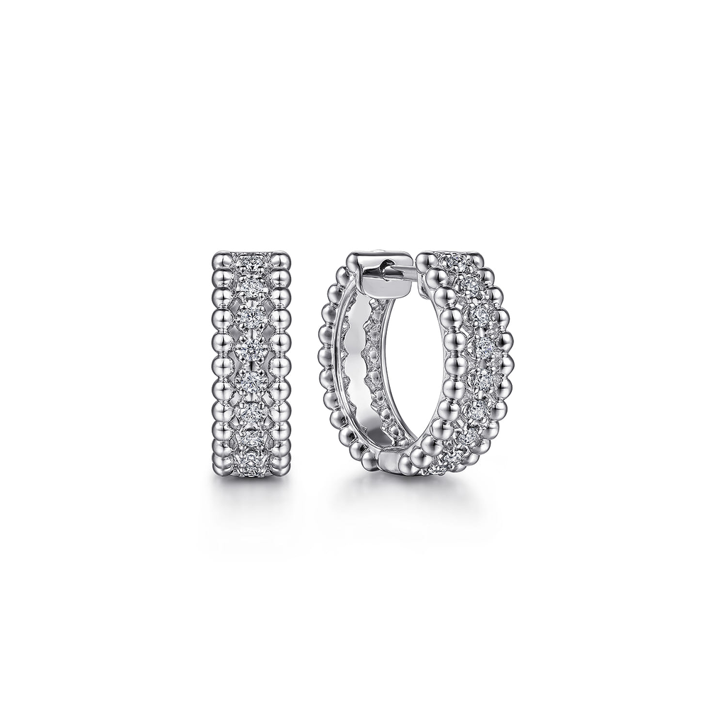 Silver hoop earrings with embedded stones on a white background